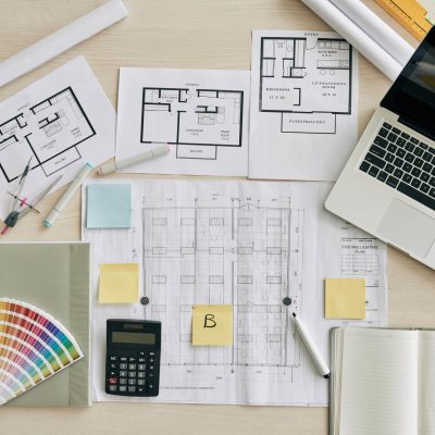 Plans and blueprints on table of interior designer, view from above